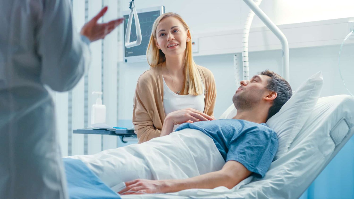 A nurse explaining something to a patient and their supporter